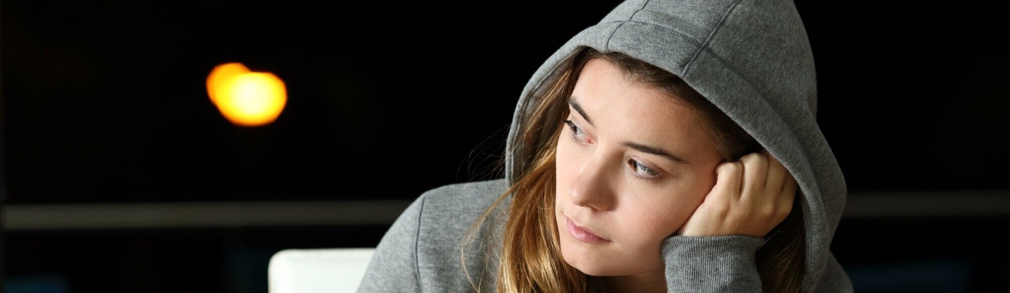 pensive teenager in hooded sweatshirt